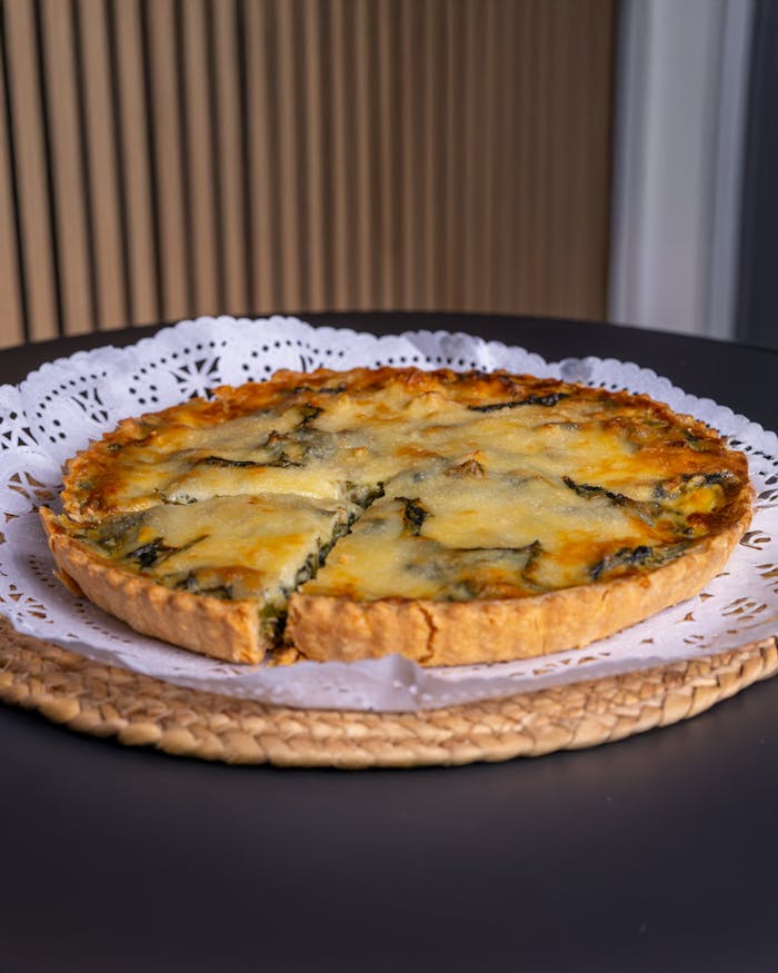 Freshly baked spinach quiche with a golden cheese topping, ready to serve.